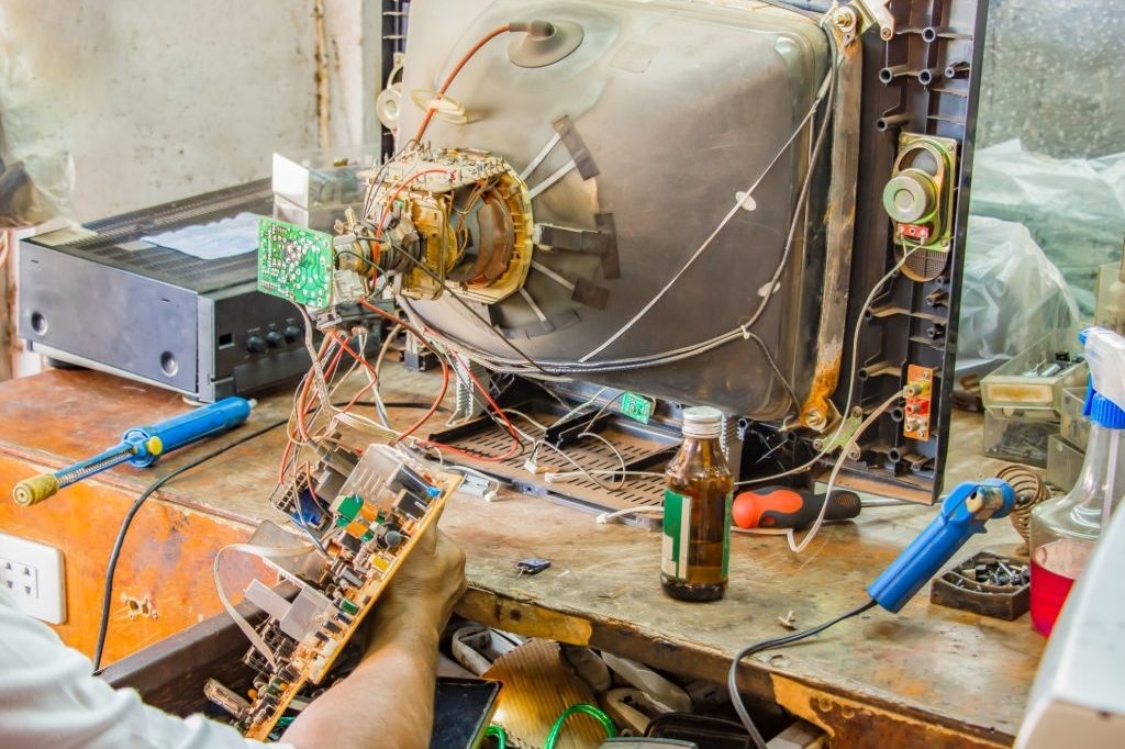 Technician repairing old television or tv in repair shop